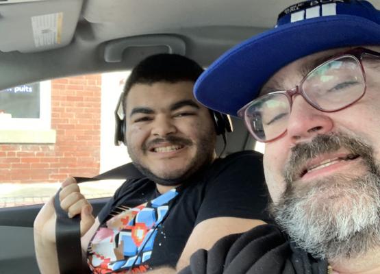 Selfie of father and teen son in car