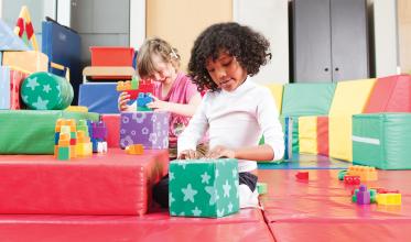 Girl playing in a brighly coloured playroom with Gifts