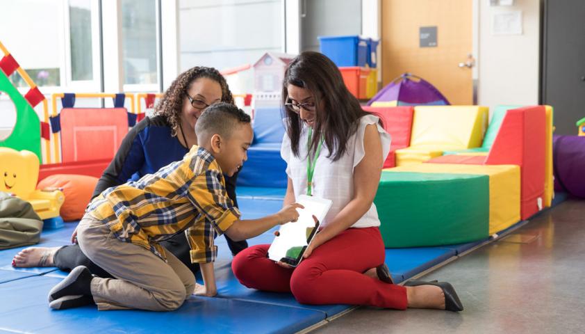 Staff with boy using iPad