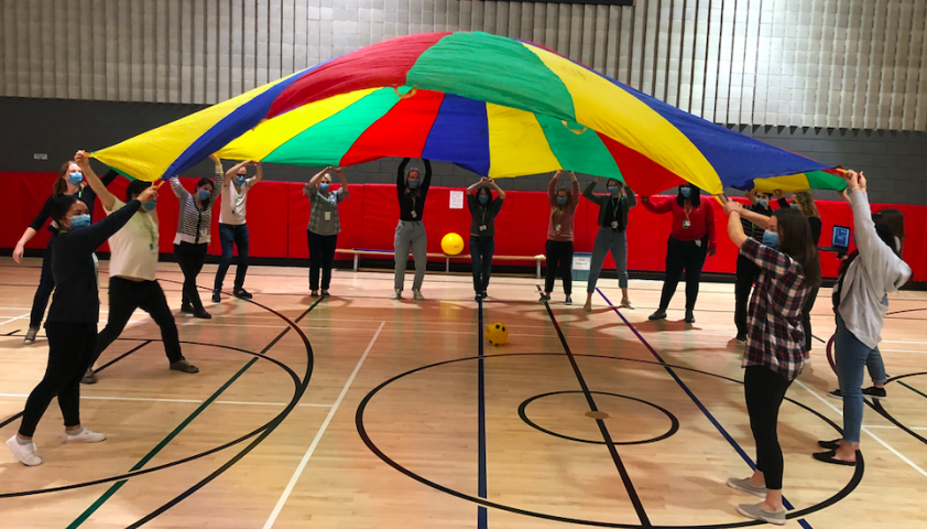 The team playing with a parachute.
