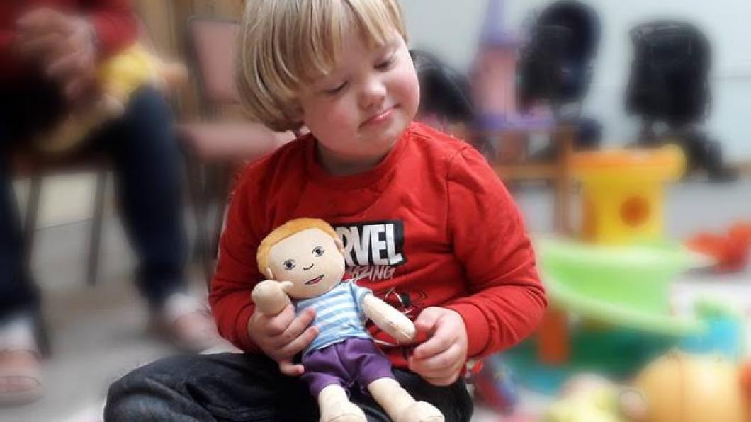 Little boy holding soft doll.