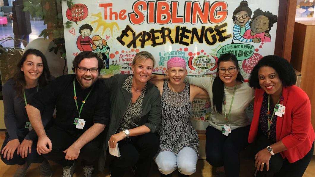 Six adults sit in front of poster called The Sibling Experience