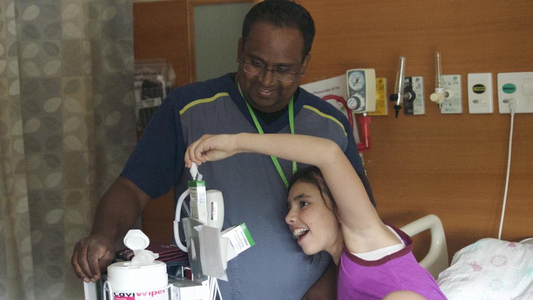 A girl takes her own temperature with male nurse