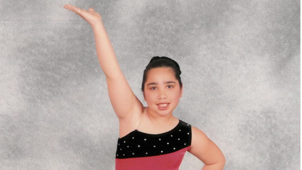 Sam as a kid posing in her dance costume. 