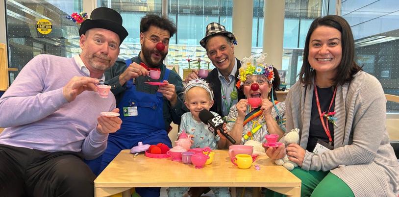 Some adults playing with a kid in a playroom
