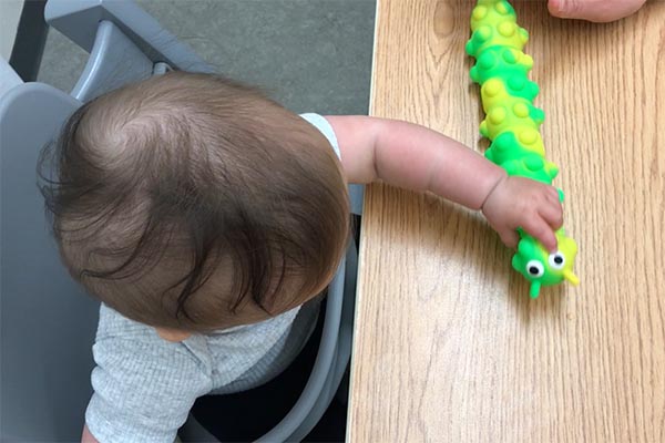Place toys with textures, sound/light in infants hand to encourage sustained holding