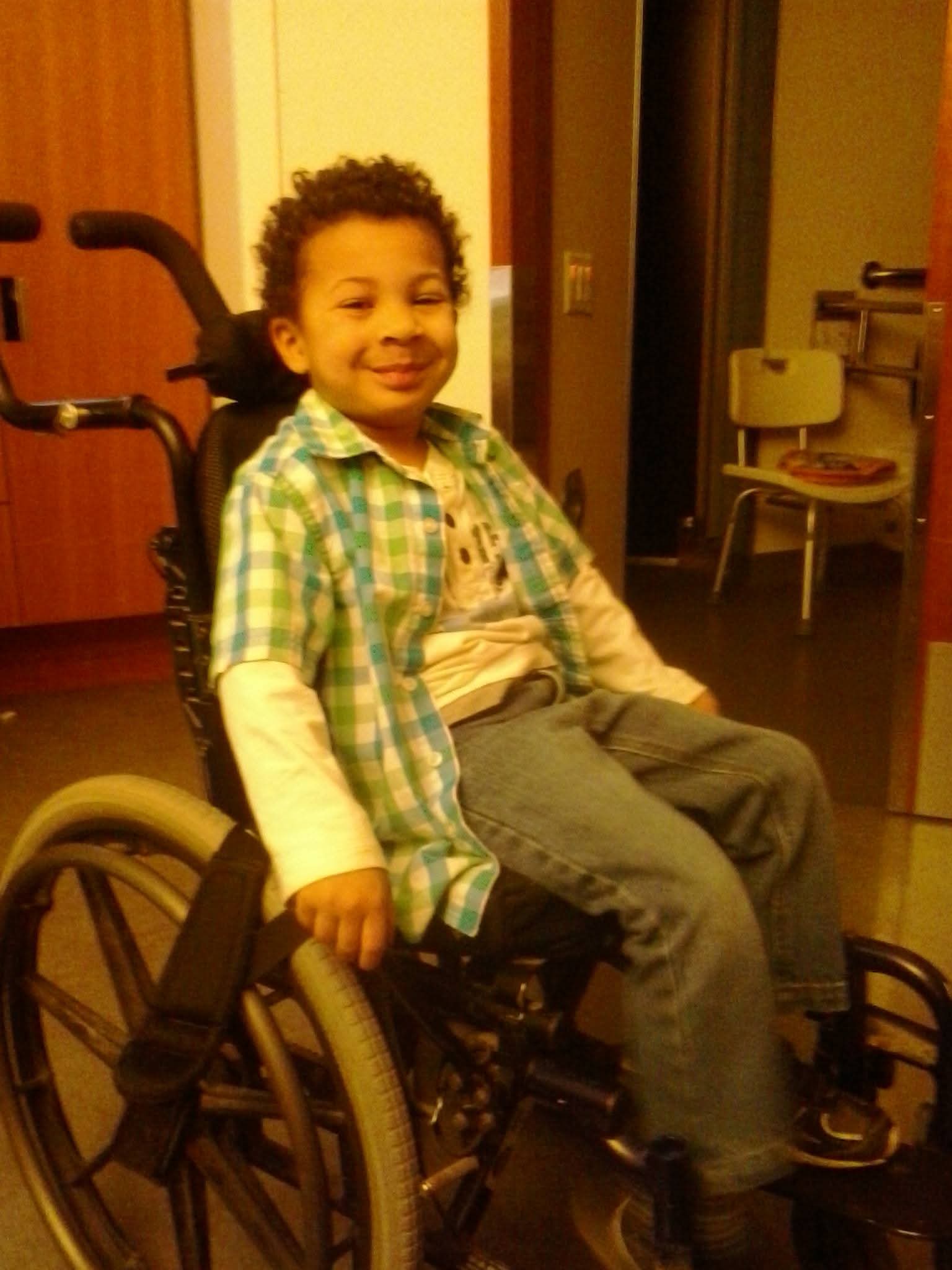 A child who uses a wheelchair smiles.