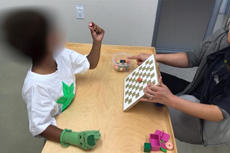 Turning wooden knobbed puzzle pieces, cubes, or baby toy cups over to look at sticker underneath (Easier – large knobs using palmer grasp. Harder – use pincer grasp).