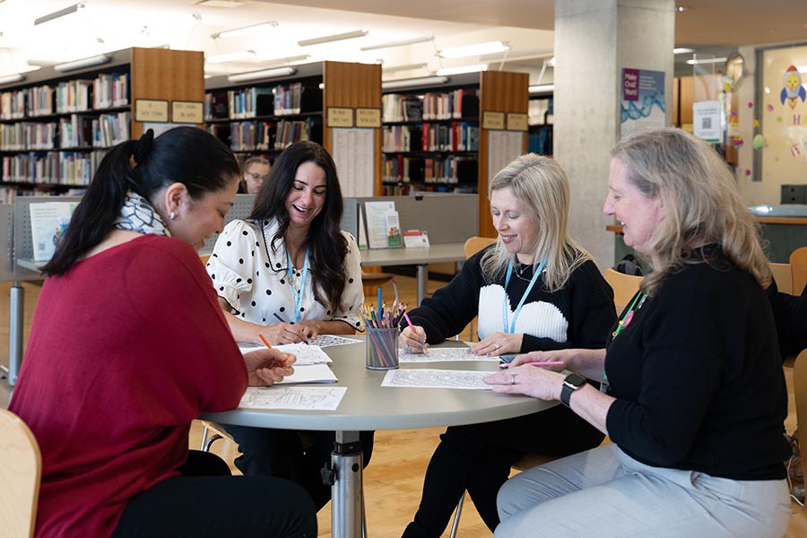 Four people working in a library setting