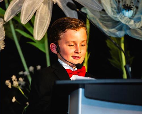 A child standing on a stage as MC