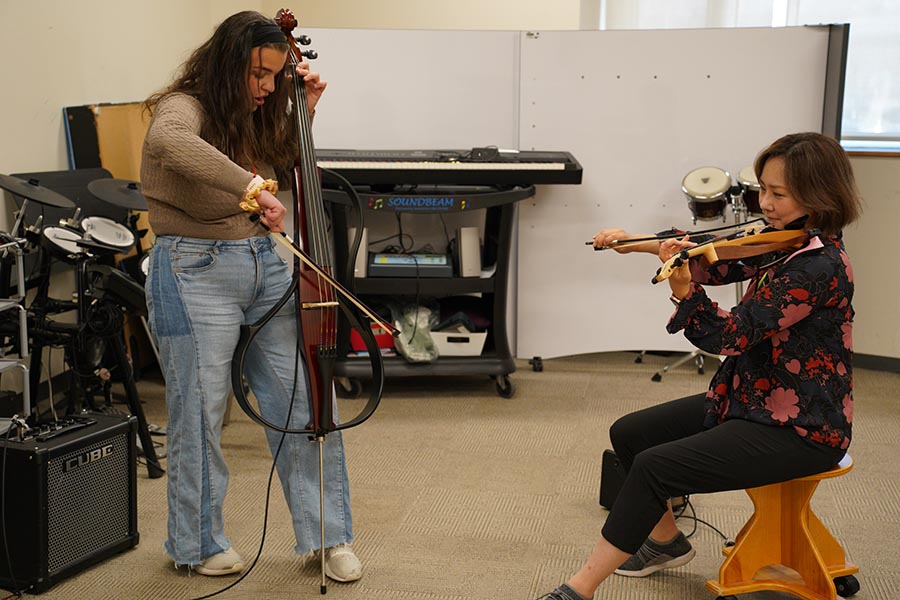 Reede Parisi, a music therapy intern, shares a moment with Eunice in the studio.