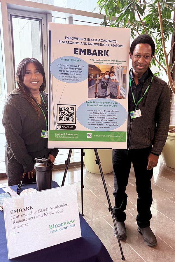 Two adults sending beside a poster