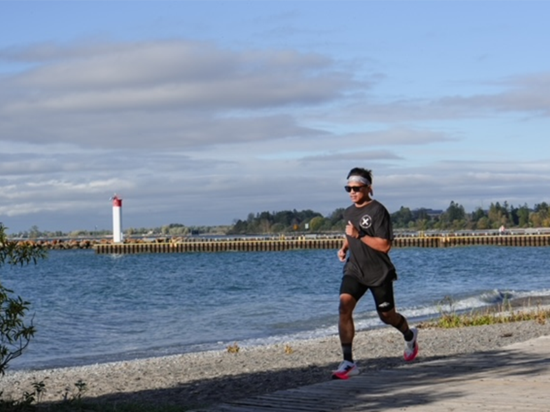 A man runs on a path beside a lake