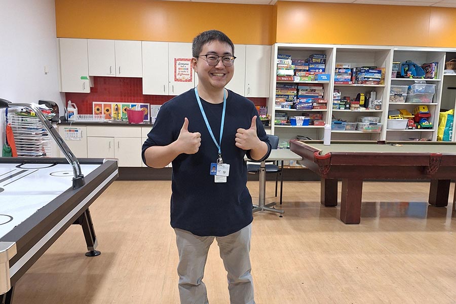 Young male volunteer standing in playroom