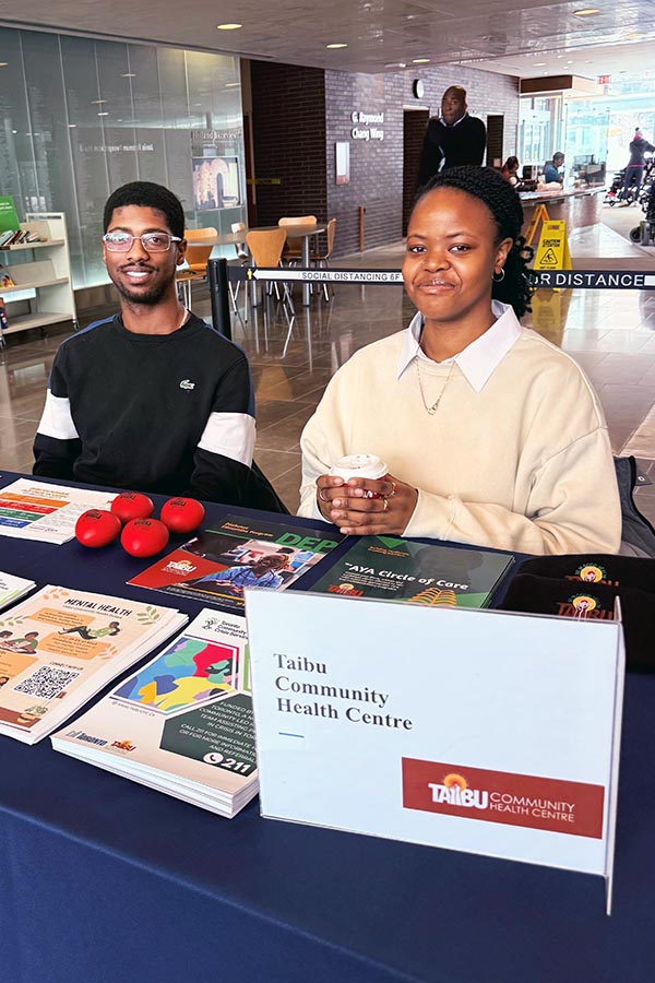 Two adults behind a booth