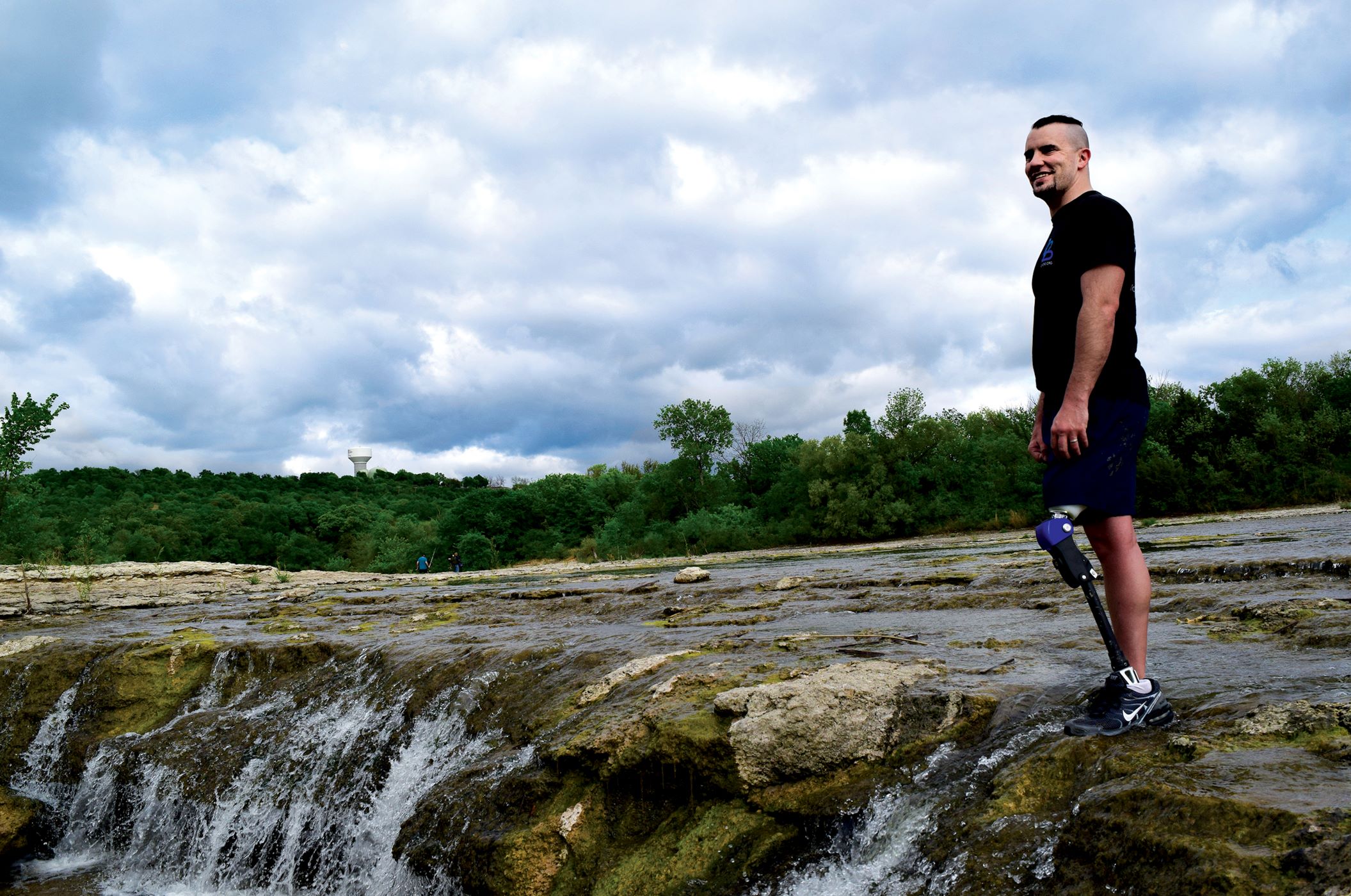 a person wearing a prosthetic knee close to a waterfall