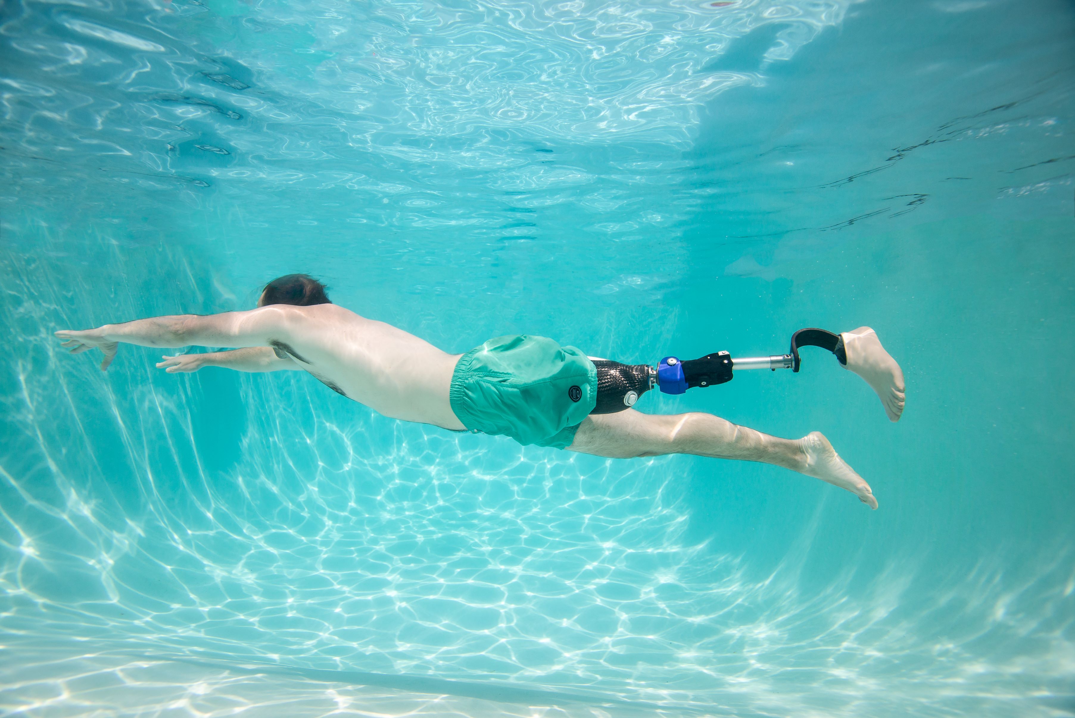 a person wearing a prosthetic knee is swimming