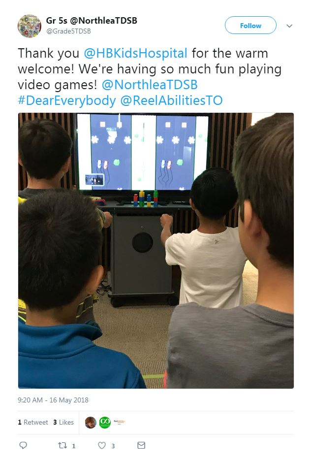 Screenshot of tweet with an image of two young boys playing a video game