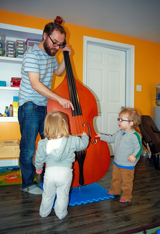 Adult playing the bass for children