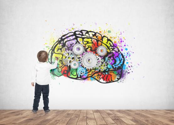 Image of small boy painting a colourful brain