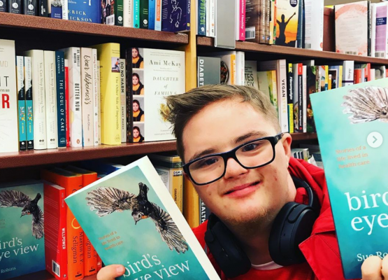 Young man holding book in book store
