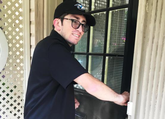 Man using a key to open his front door