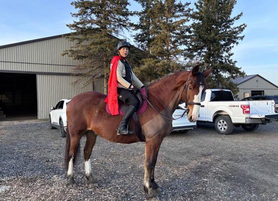 Woman in red cape on horse