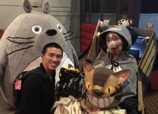 Man wearing Totoro costume beside another man with large plush character