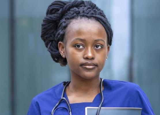 Woman with hair in braids wearing scrubs