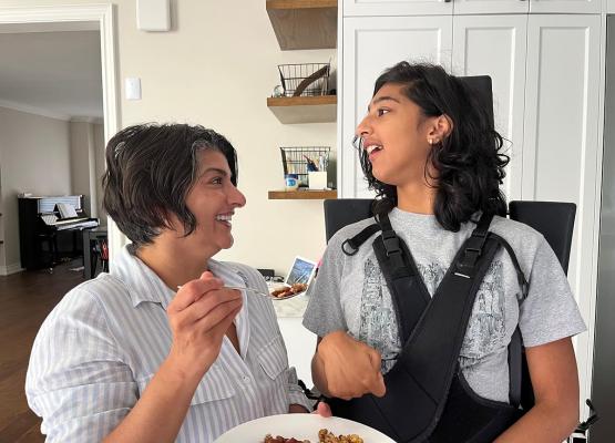 Woman feeds teen girl who uses wheelchair