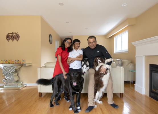 Boy in the middle of woman and man with three dogs