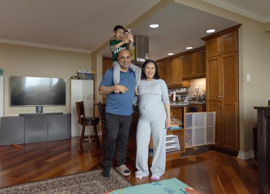 Man with young son on shoulders beside woman