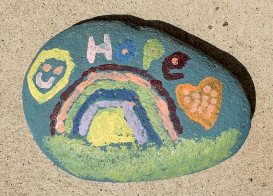 Image of a painted rock with the word hope and a rainbow