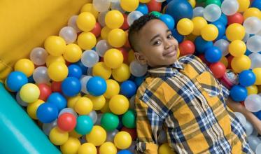 Young boy laying in ball pit