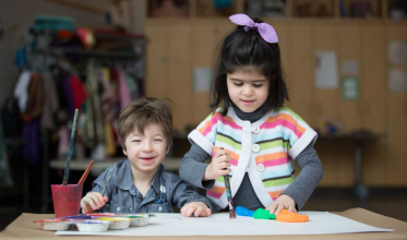 Two young girls painting.