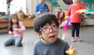 Young boy with glasses smiling at the camera 