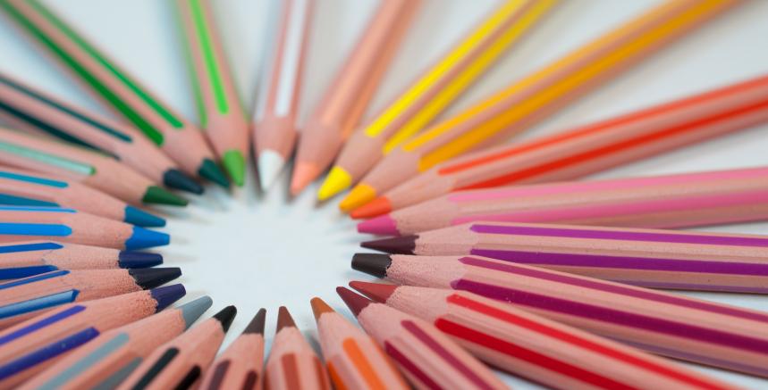 coloured pencil crayons positioned in a circle with pencil tips facing the middle