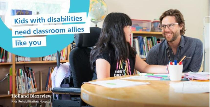 Picture of a student and teacher looking at each other seated behind a desk