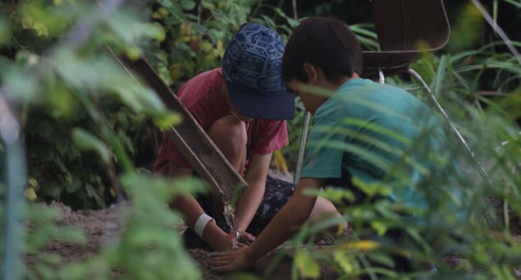 Two kids tending to the garden