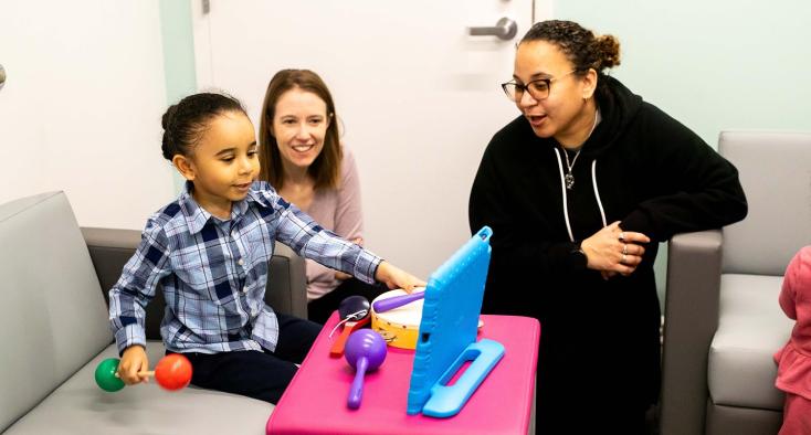 Two adults playing with a young kid
