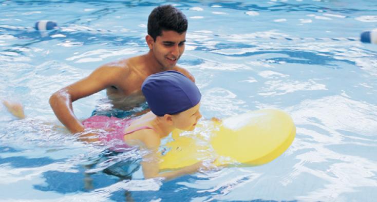 Volunteer in swimming pool with client