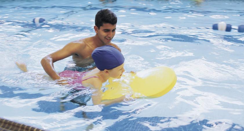 Volunteer in swimming pool with client