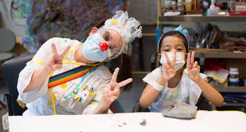 Nurse Flutter and client wearing masks at the art table