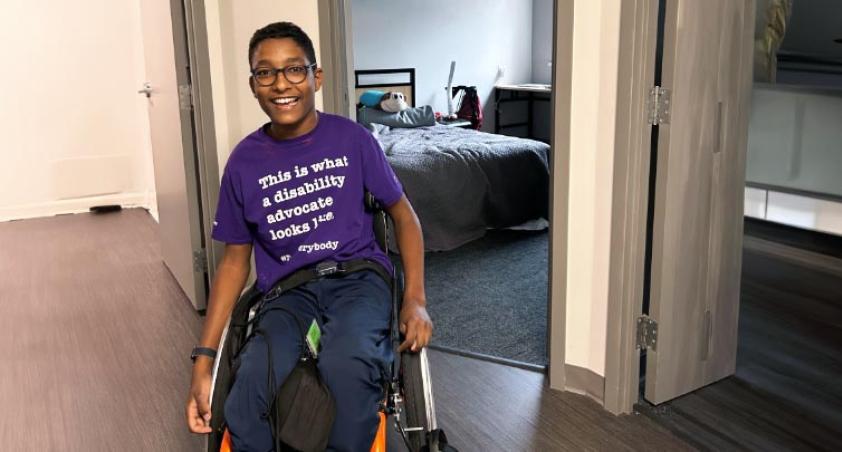 A teenager on wheelchair wearing a happy smile