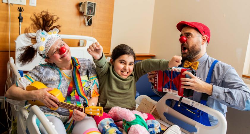 Client bedside with therapeutic clowns