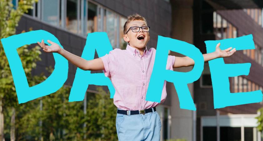 A child with his hands open, and the word DARE behind him