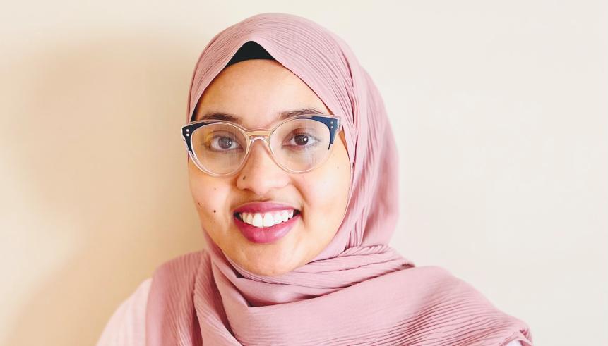 A woman with glasses and a pink hijab.