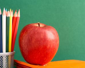 apple and colouring pencils on a desk