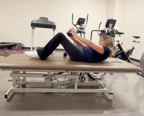A person doing workout on a gym bed