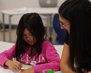 A child and an adult playing Bingo at a table